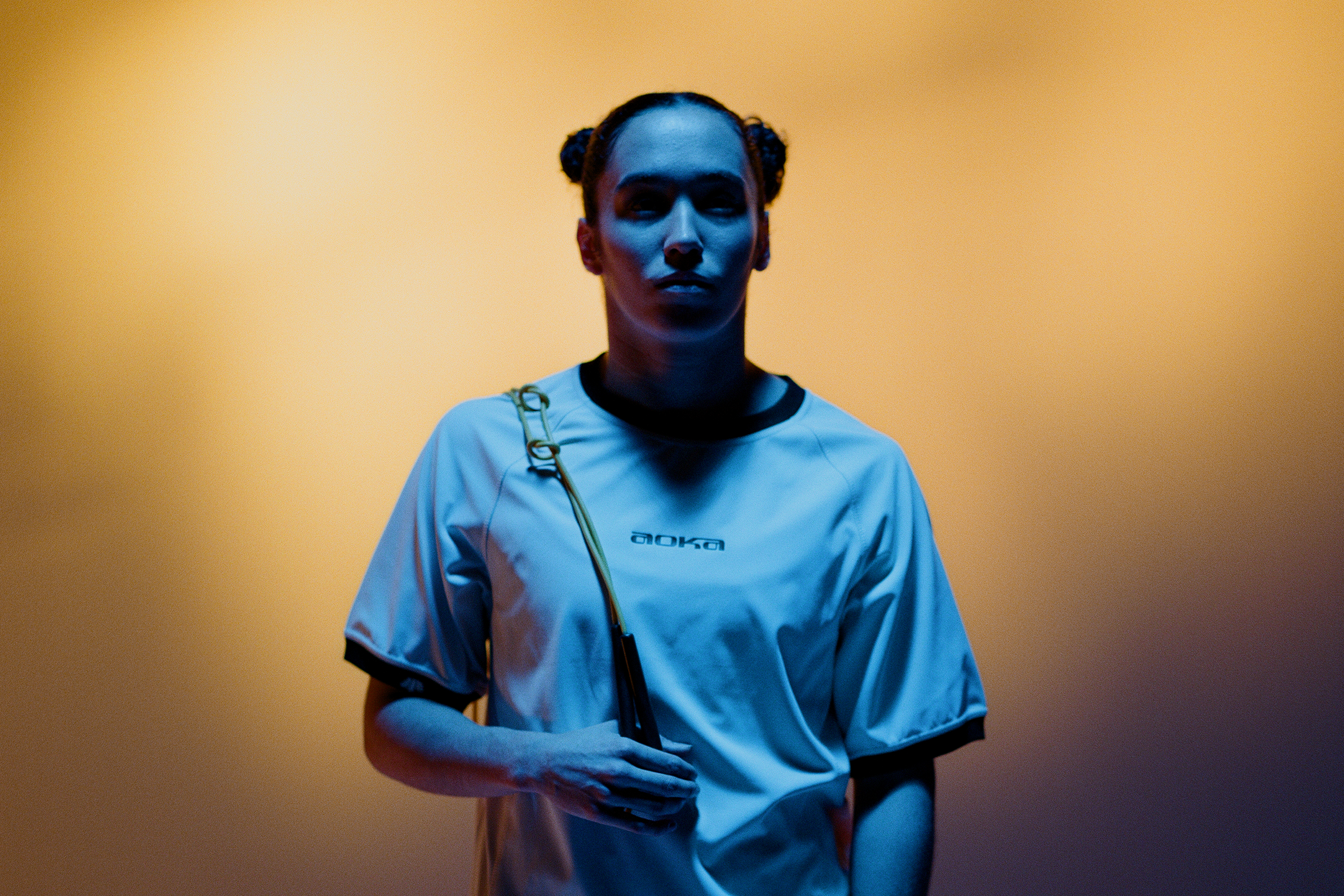 Person wearing a white sports outfit with a dark background